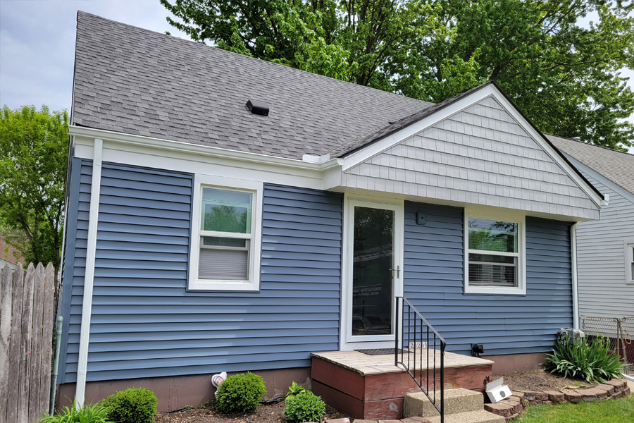 A blue house with white trim and black shutters.