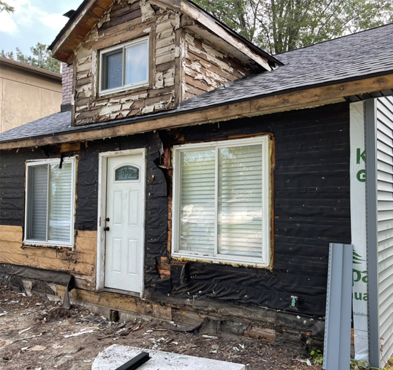 A house that has been boarded up and is being remodeled.