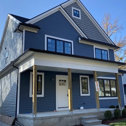 A blue house with white trim and a porch.