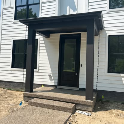 A porch with steps leading to the front door.