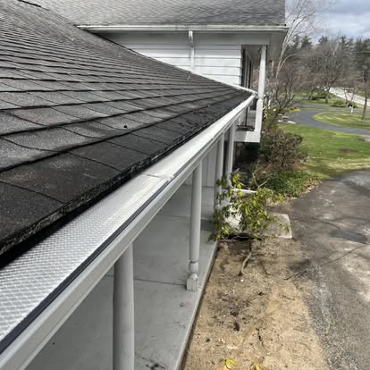 A house with a gutter and roof that is missing the gutter cover.