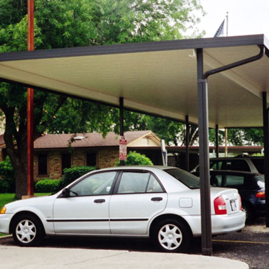 A car parked in the shade of a covered parking lot.