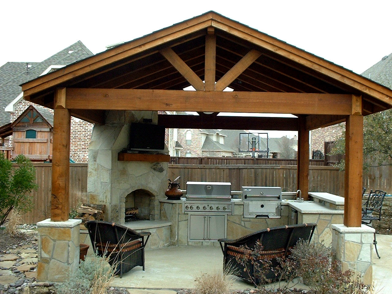 A covered outdoor kitchen with an oven and grill.