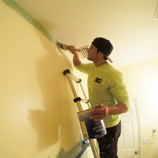 A man painting the wall of his home.