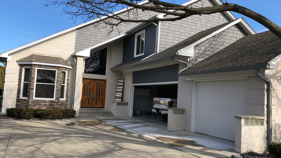 A house with two cars parked in the driveway.