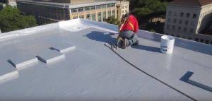 A man kneeling on top of a roof.