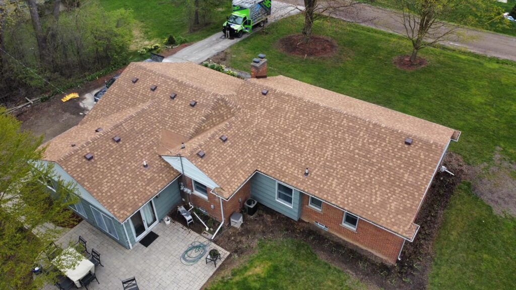 Aerial view of an aging brown asphalt roof before replacement