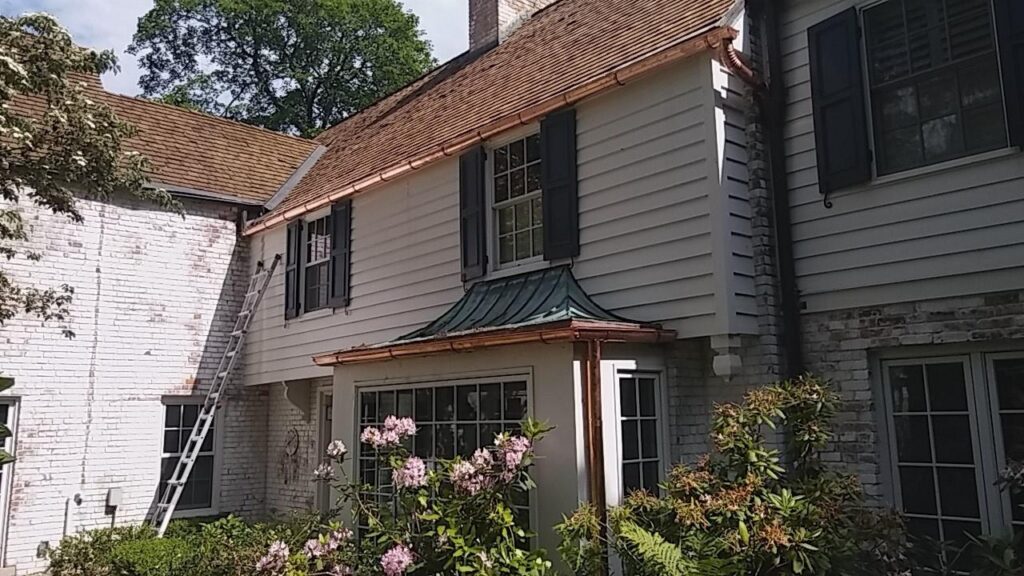 Copper gutter installation along roof edge