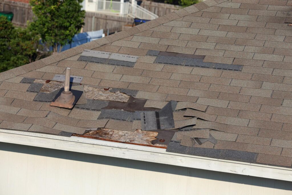 Damaged asphalt shingles before roof repair