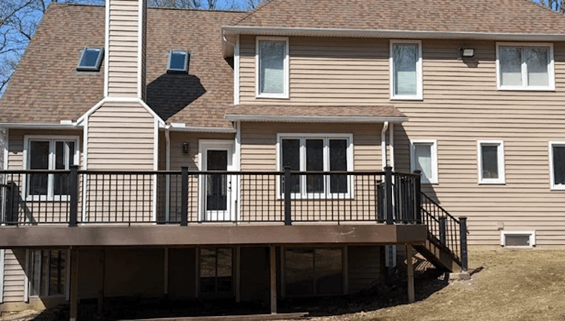 A brown house with a deck and stairs